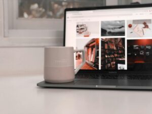 white ceramic mug beside black laptop computer